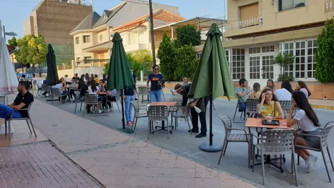 Dos jóvenes tomando un refresco en una terraza de un bar