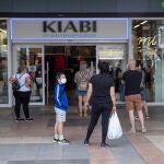 Varias personas esperan la hora de apertura de una tienda de ropa en el centro comercial Thader de Murcia