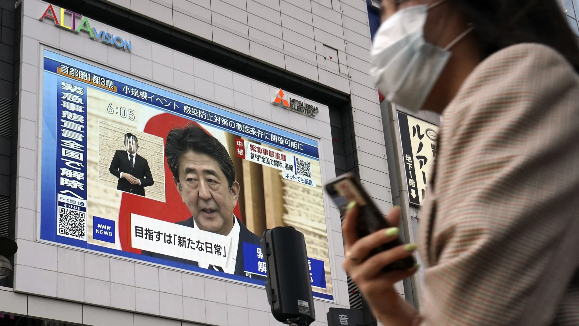 Una pantalla gigante en Tokio muestra este lunes al primer ministro, Shinzo Abe, anunciando el levantamiento del estado de alarma
