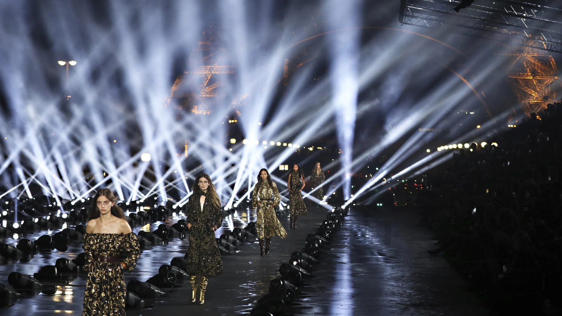 FILE - In this Sept.24, 2019 file photos, models wear creations as part of the Saint Laurent Ready To Wear Spring-Summer 2020 collection, unveiled during the fashion week, in Paris. Gucci and St. Laurent are two of the highest profile fashion houses to announce they will leave the fashion calendar behind, with its relentless four-times a year rhythm, shuttling cadres of fashionistas to global capitals where they squeeze shoulder-to-shoulder around runways for 15 breathless minutes. The coronavirus lockdown -- which has hit luxury fashion houses on their bottom lines -- has also given pause to rethink the pace of fashion. (Photo by Vianney Le Caer/Invision/AP, File)