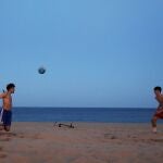 Dos jóvenes juegan al balón en una playa de Barcelona