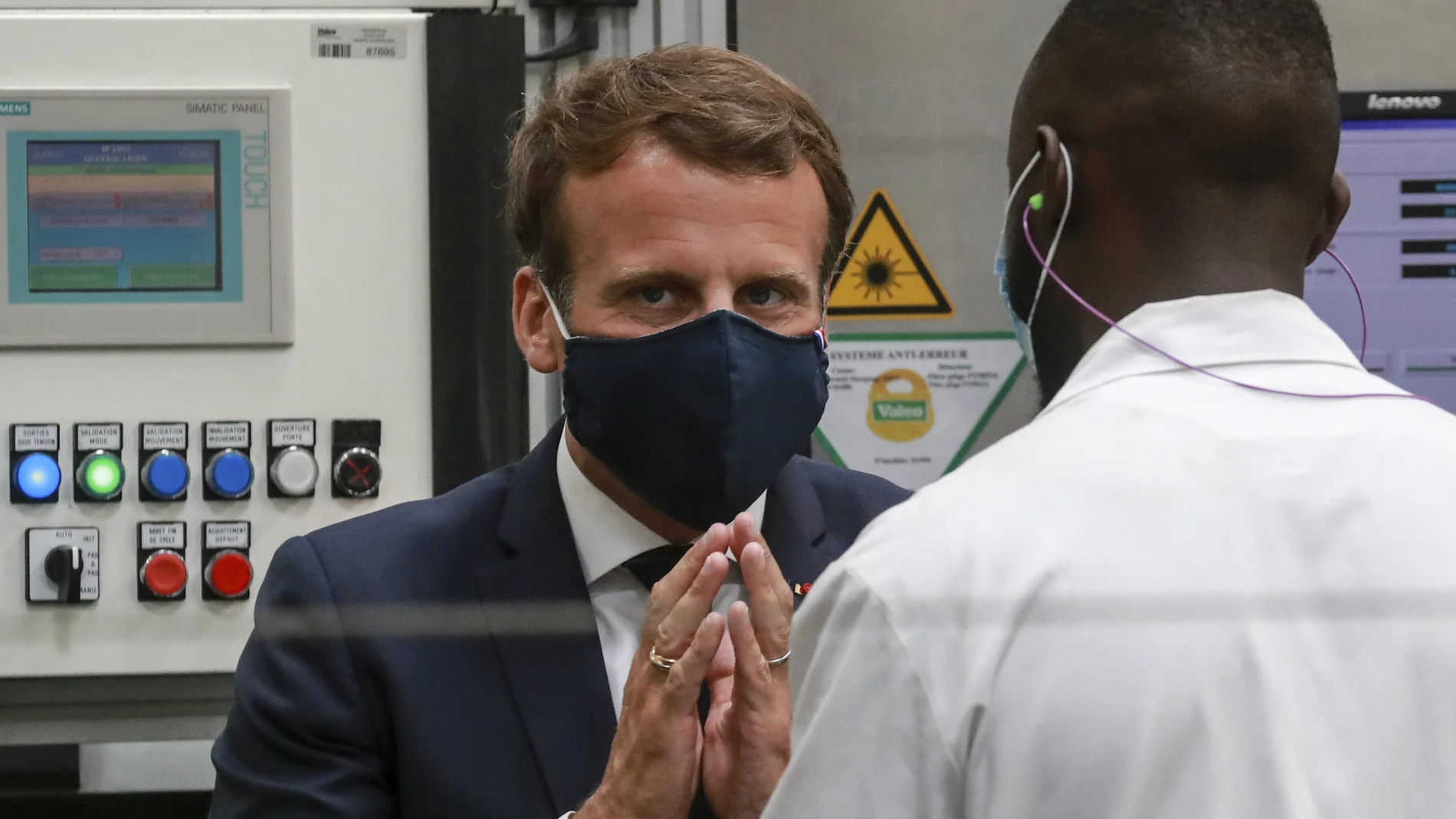 El presidente francés, Emmanuel Macron, con mascarilla, charla con un trabajador de la planta de Valeo en Etaples