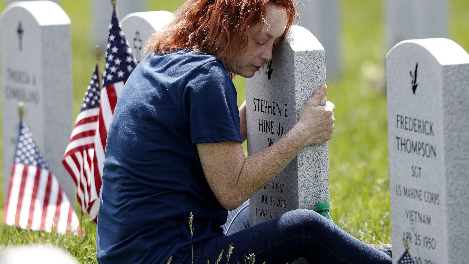 Mom hugs tombstone of son at the Ohio Western Reserve National Cemetery on Memorial Day in Seville