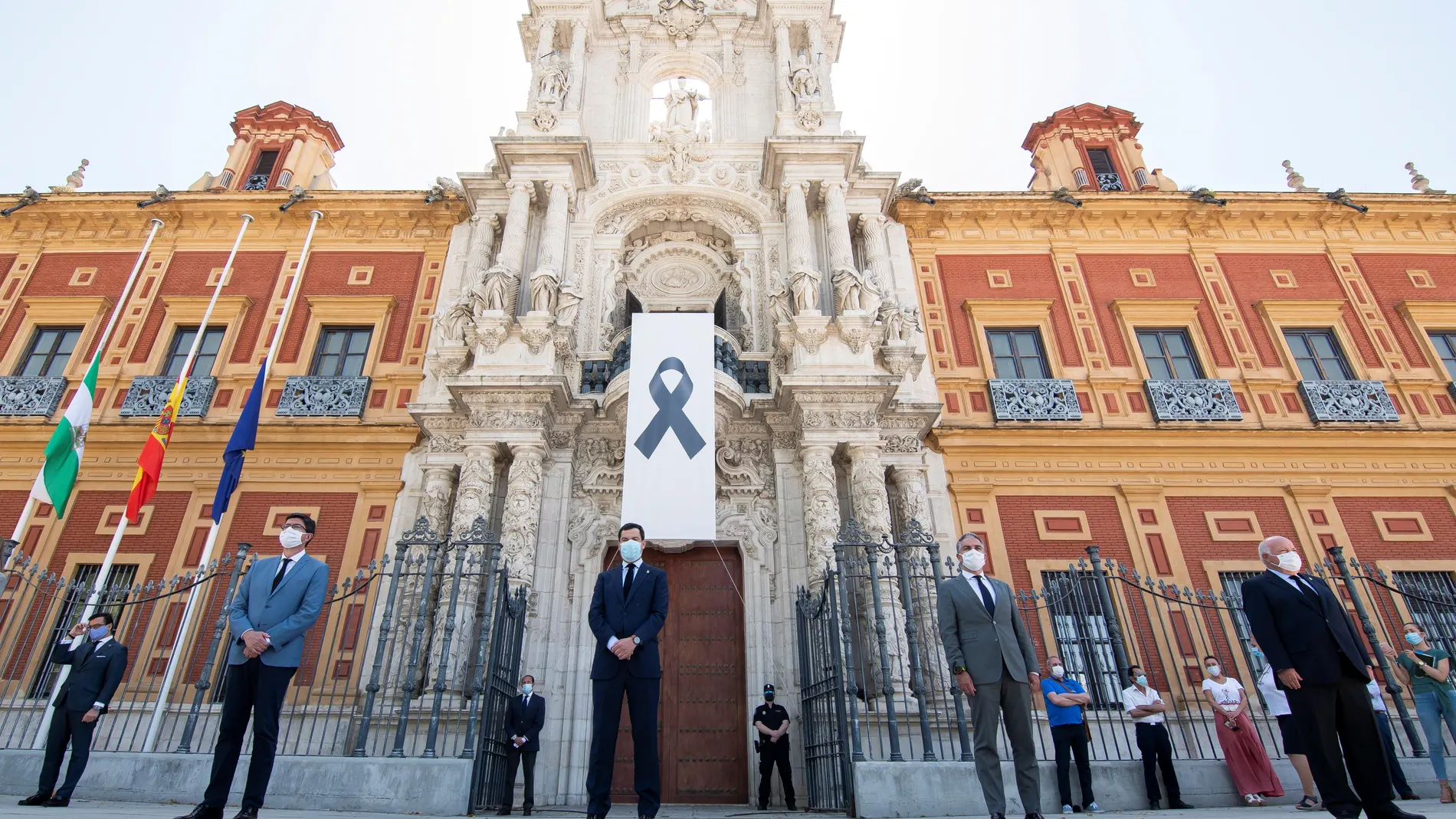El Gobierno andaluz, con Juanma Moreno a la cabeza (c), durante el minuto de silencio a las puertas de San Telmo