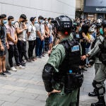 Varios policías custodiann a varios manifestantes en las protestas contra la nueva ley de seguridad nacional