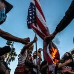 Un grupo de manifestantes quema una bandera de Estados Unidos durante las protestas por la muerte de George Floyd a manos de la policía de Minneapolis