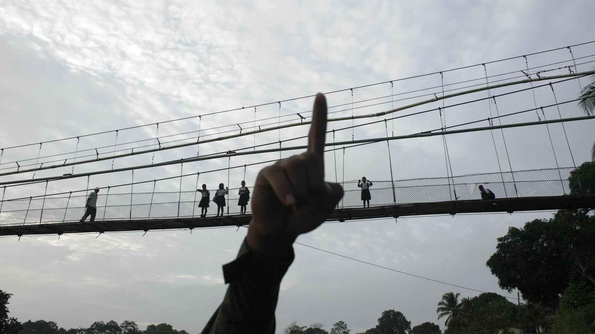 FILE - In this June 19, 2018 file photo, a Panama border police officer points as he begins to patrol in the Darien Province, on the border with Colombia, in Yaviza, Panama. As Panama deals with the care of migrants living in shelters in the jungle province of Darien in May 2020, the Inter-American court ordered Panama to take urgent measures to protect migrants' lives in the midst of the coronavirus pandemic. (AP Photo/Arnulfo Franco, File)