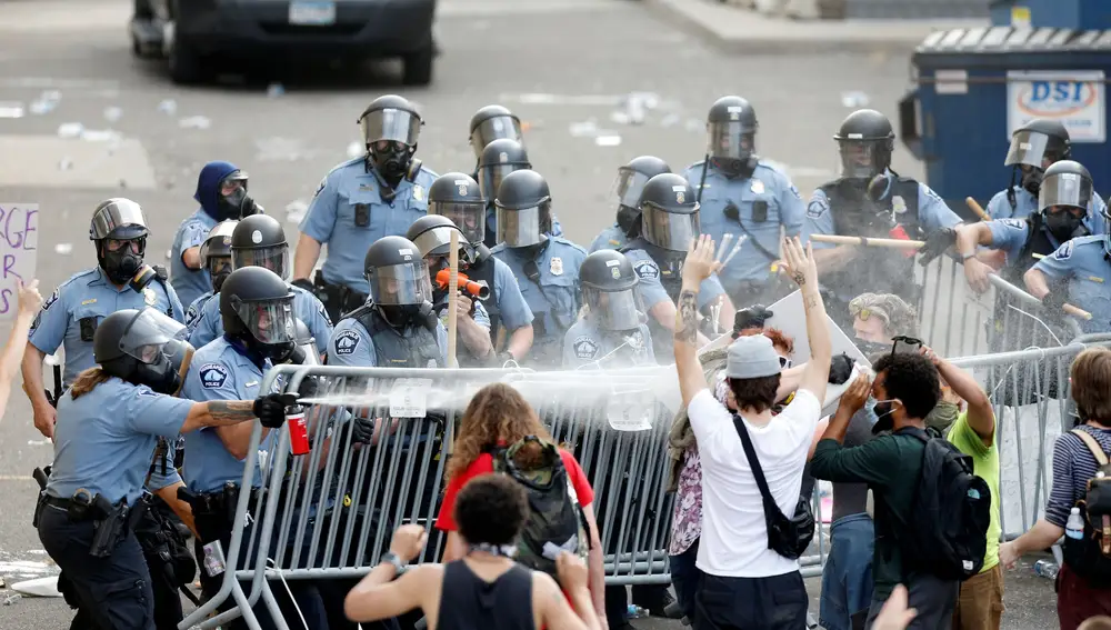 Varios agentes tratan de contener a los manifestantes en una de las batallas campales que han tenido lugar en Minneápolis