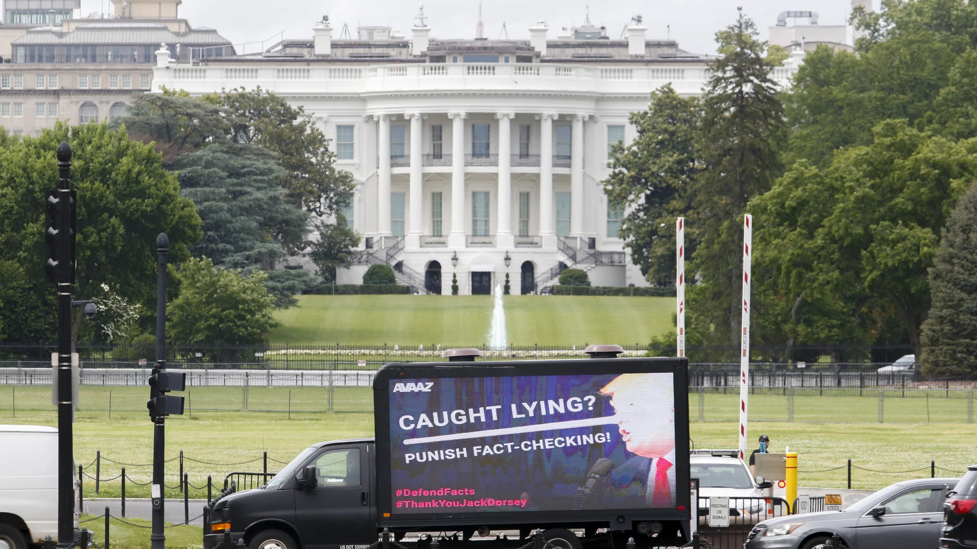 Un cartel móvil contra el presidente Trump pasa por delante de la Casa Blanca