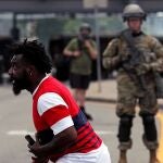 Un hombre delante de un agente de la Guardia Nacional de EE UU en una protesta en Minneapolis
