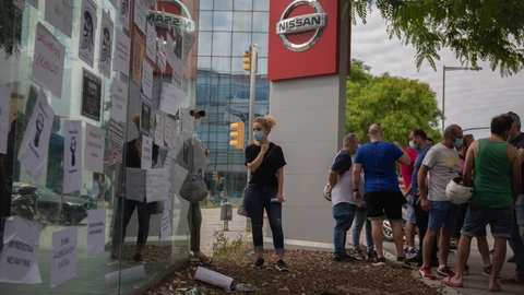 Trabajadores de Nissan cuelgan carteles como signo de protesta en el corte que han realizado en la Gran Vía de L’Hospital (Barcelona), cerca del concesionario de Nissan Motor Llansà.