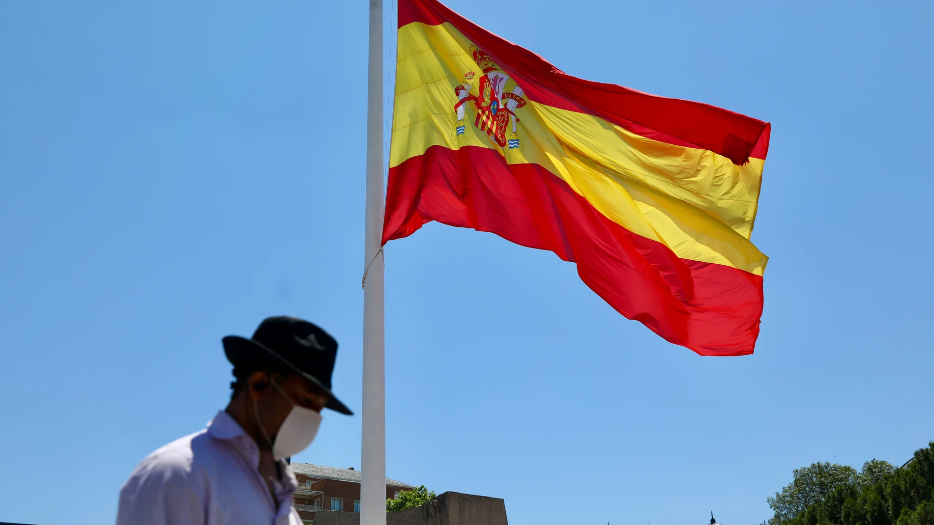 Un hombre camina con mascarilla por la plaza de Colón en Madrid