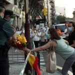 Participantes en una protesta del pasado sábado por las calles de Zaragoza ofrecen un ramo de flores a dos miembros de la Guardia Civil