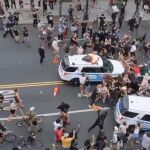 Momento en que un coche de policía arrolla a manifestantes en Nueva York