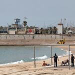 Agentes de la Guardia Urbana informan a una pareja sobre la prohibición de tomar el sol tumbados en la playa de la Nova Icaria de Barcelona