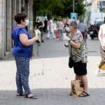 Dos mujeres mantienen la distancia social mientras hablan en una calle de Barcelona este martes