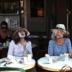 Clientas disfrutan de la tarde primaveral en el "Cafe de Flore" del barrio Latino de París