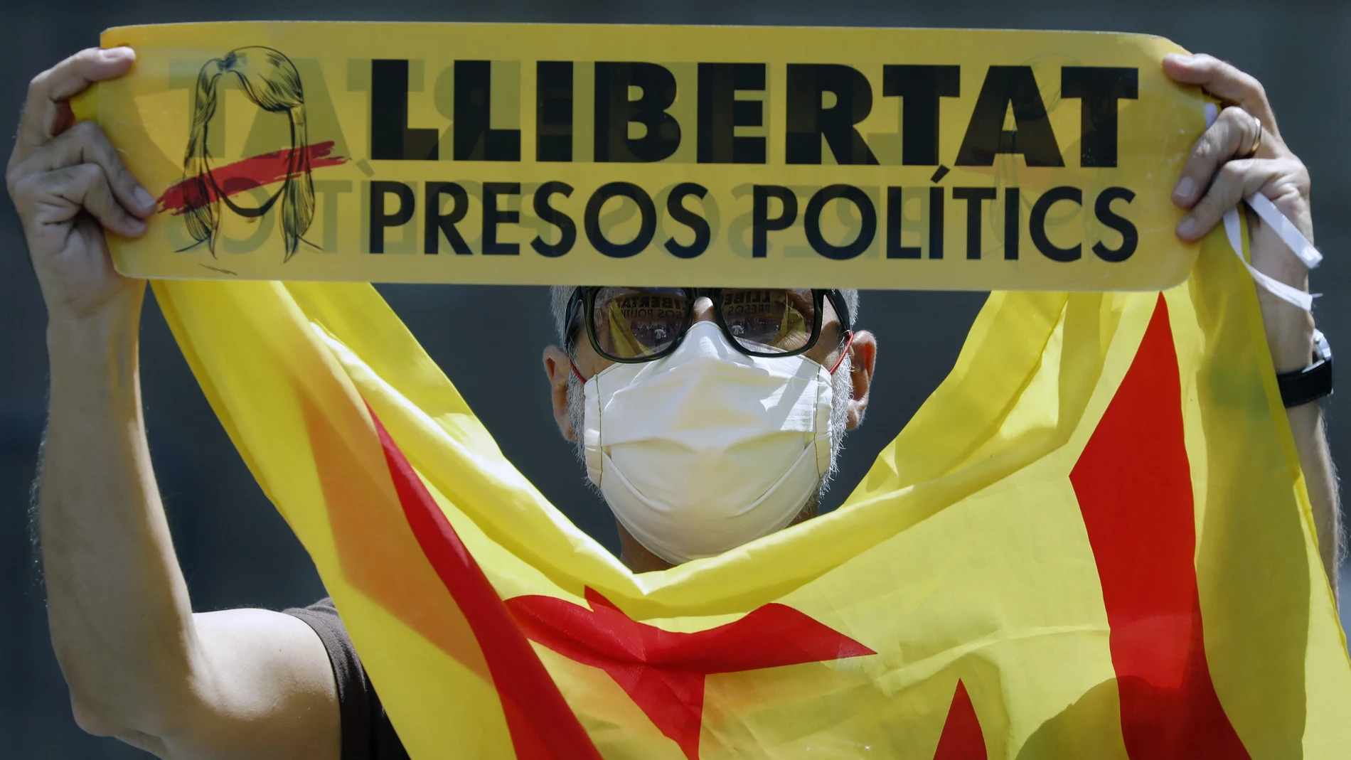 Un ciudadano exhibe un cartel a favor de la libertad de los políticos presos, durante una concentración ayer en la plaza de Sant Jaume de Barcelona