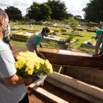 Empleados preparan a víctimas de COVID-19 para ser enterrados este miércoles, en el cementerio de Campo da Esperança, en Brasilia