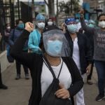 Nurses and doctors chant slogans as they protest the lack of protective equipment for health workers attending COVID-19 patients, outside a public hospital in Lima, Peru, Tuesday, June, 2, 2020. (AP Photo/Rodrigo Abd)