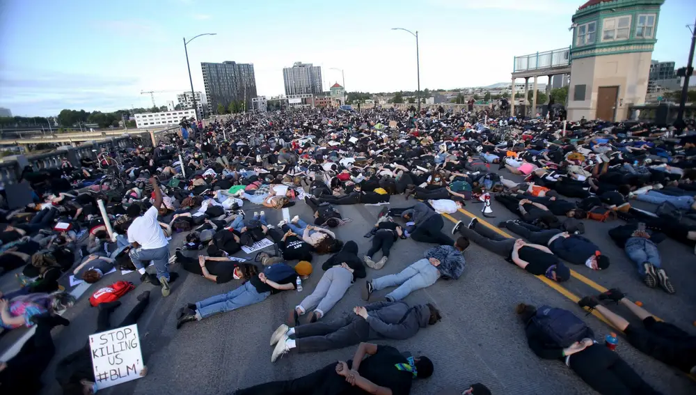 Los manifestantes se tumban en el puente Burnside durante nueve minutos simbolizando la cantidad de tiempo que un oficial de policía de Minneapolis se arrodilló en el cuello de George Floyd
