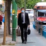Imagen de archivo de un hombre, equipado con mascarilla, caminando por una calle de Sevilla