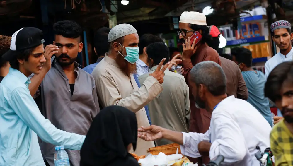 Un hombre con mascarilla en el concurrido mercado electrónico en Karachi, Pakistán