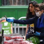 Una clienta con mascarilla compra en el Borough Market de Londres
