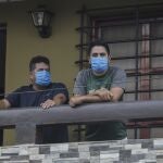 Norman Cardoze Sr., left, and his son Norman Cardoze Jr. pose for a photo from the balcony of their home where they are in quarantine after catching the new coronavirus in Managua, Nicaragua, Wednesday, May 27, 2020. During a May 16 game, manager Norman Cardoze Sr. and coach Carlos Aranda felt sick. Cardozeâ€™s son Norman Jr., the teamâ€™s star slugger, was so weak and achy he didnâ€™t play. Within two days all three men were hospitalized, where the Cardozes spent a week and Aranda died. (AP Photo/Alfredo Zuniga)