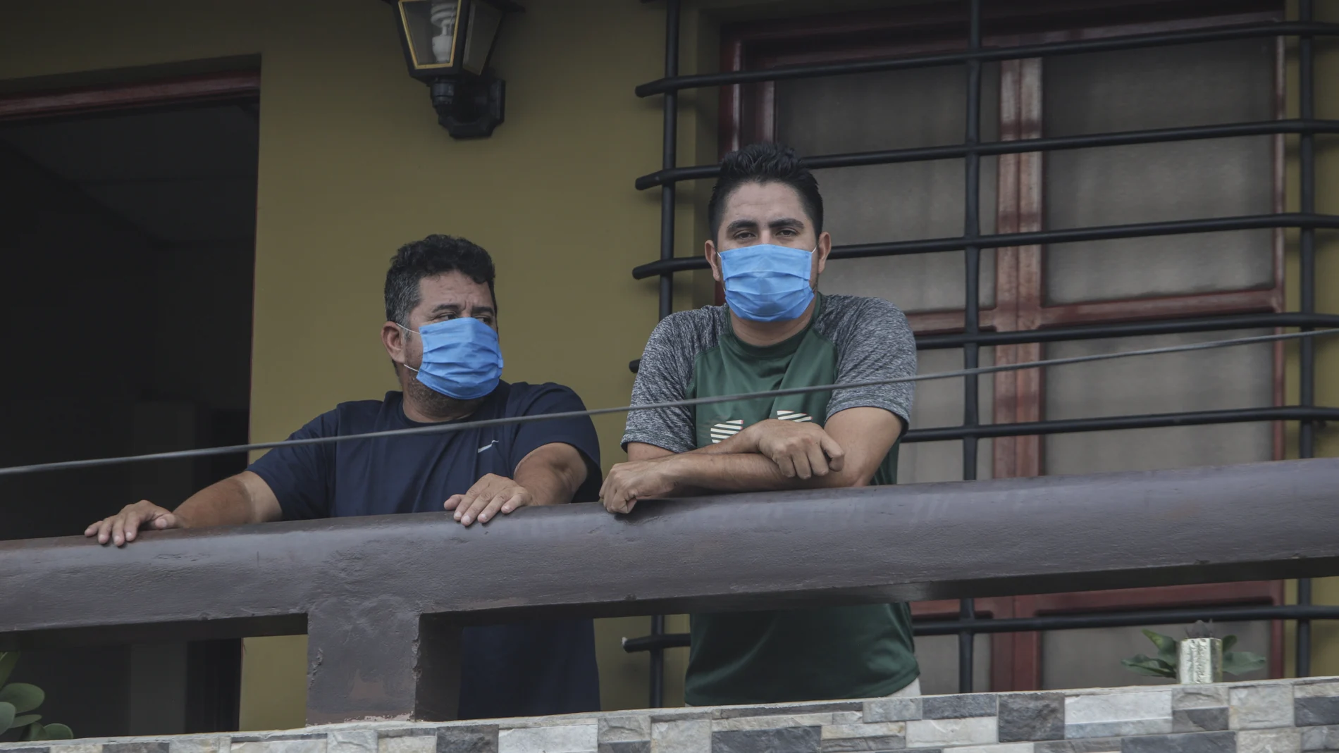Norman Cardoze Sr., left, and his son Norman Cardoze Jr. pose for a photo from the balcony of their home where they are in quarantine after catching the new coronavirus in Managua, Nicaragua, Wednesday, May 27, 2020. During a May 16 game, manager Norman Cardoze Sr. and coach Carlos Aranda felt sick. Cardozeâ€™s son Norman Jr., the teamâ€™s star slugger, was so weak and achy he didnâ€™t play. Within two days all three men were hospitalized, where the Cardozes spent a week and Aranda died. (AP Photo/Alfredo Zuniga)