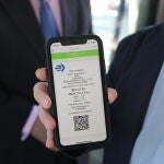El delegado del Área de Medio Ambiente y Movilidad, Borja Carabante, muestras en su teléfono móvil el nuevo método de pago mediante QR para el billete sencillo implantado en los autobuses de la Empresa Municipal de Transportes (EMT)