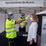 Un sanitario toma la temperatura a una mujer