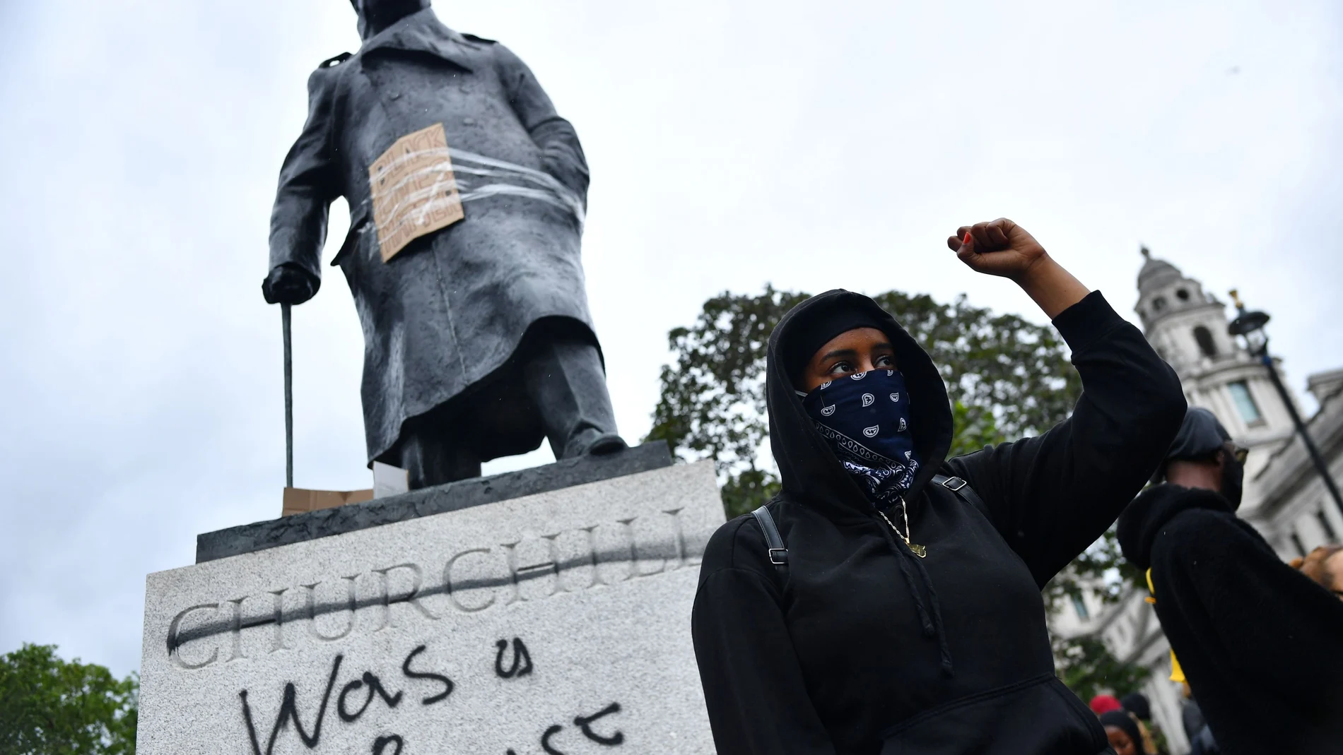 Un manifestante delante de la estatua de Churchill