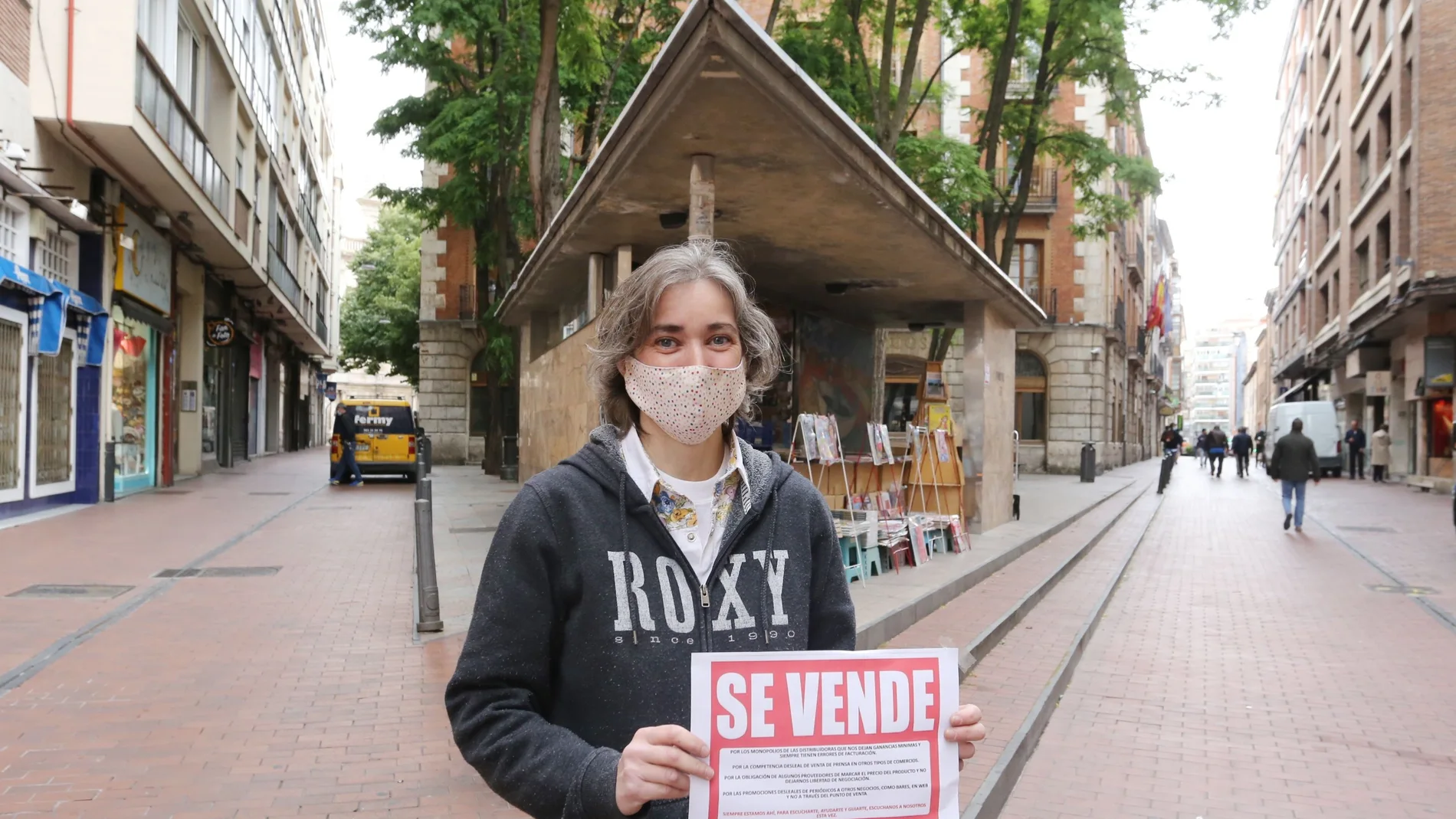 Una propietaria de un quiosco de Valladolid muestra el cartel de "Se Vende"