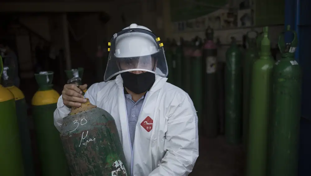 Un trabajador de una tienda en la que rellenan los cilindros de oxígeno, en Lima