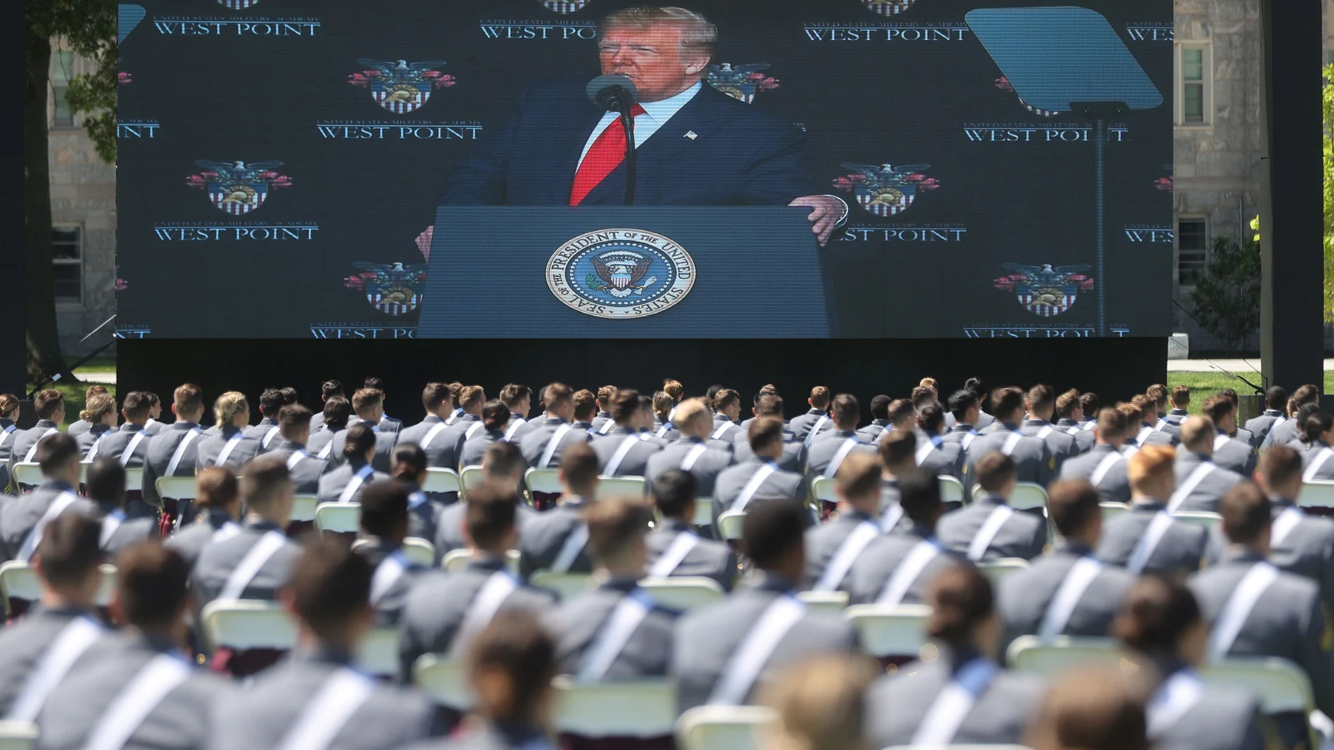 U.S. President Trump is displayed on a screen as he delivers remarks to West Point graduating cadets during their 2020 United States Military Academy graduation ceremony at West Point, New York