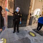 Un guardia de seguridad toma la temperatura a una joven en la Puerta del León del Real Alcázar de Sevilla