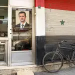Una imagen del presidente sirio, Bachar al Asad, en la puerta de una charcutería en Damasco