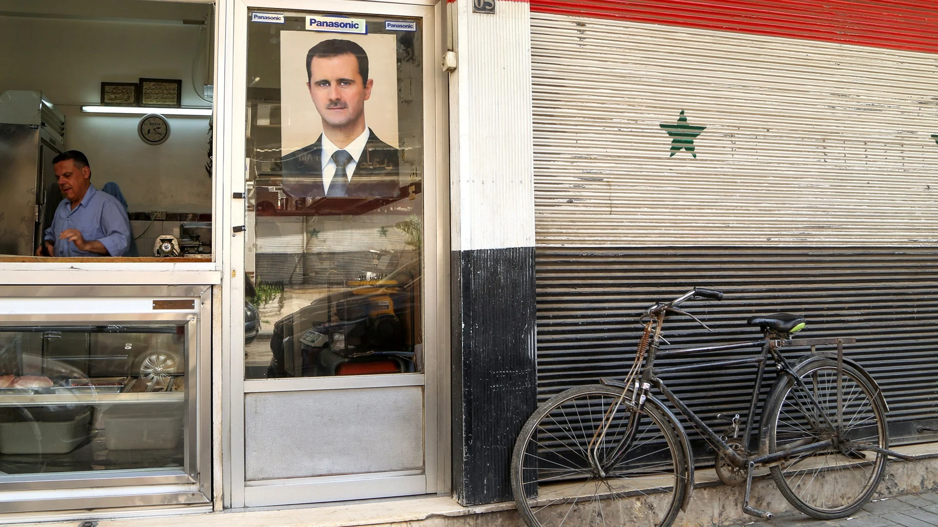 FILE PHOTO: A picture of Syrian President Bashar al-Assad is seen on a door of a butcher shop, during a lockdown to prevent the spread of the coronavirus disease (COVID-19), in Damascus