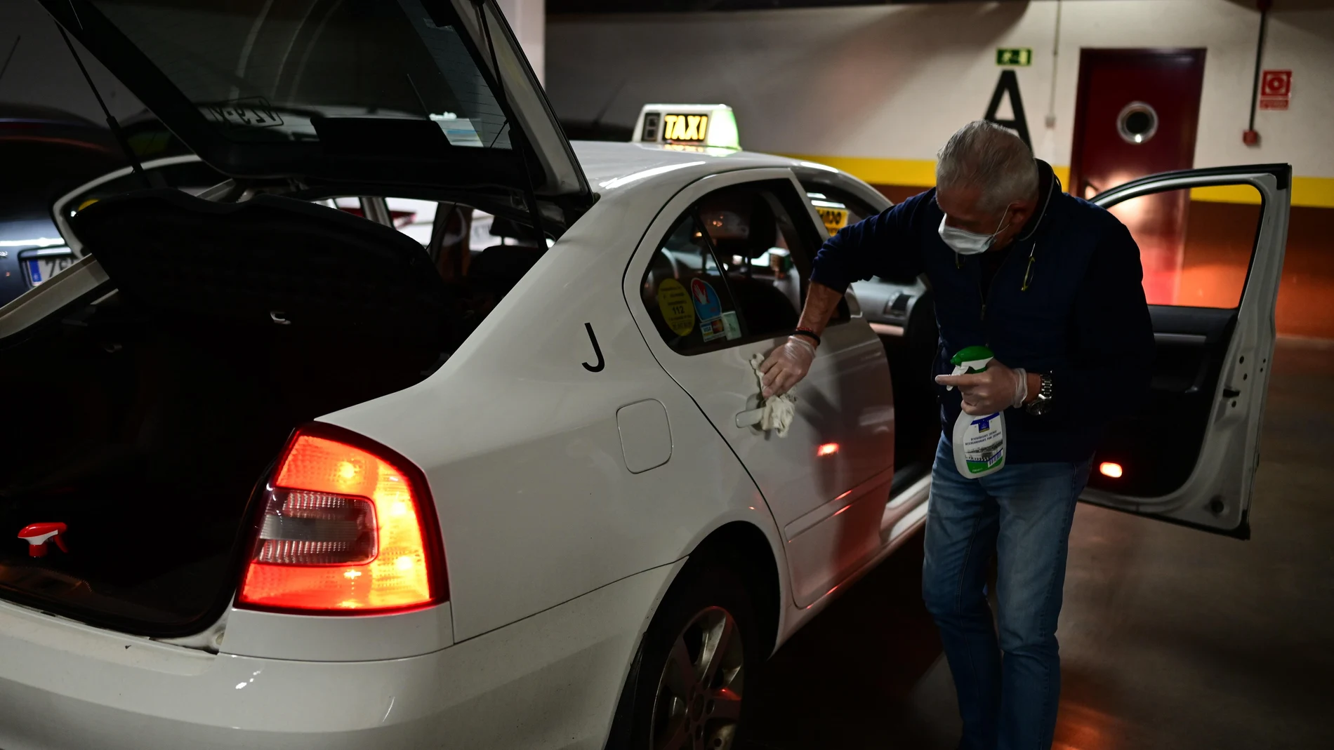 Un taxista procede a la limpieza de su vehículo en un garaje de la Colonia de los Taxistas en Vallecas, Madrid