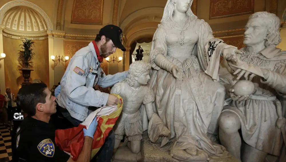 FILE â€” In this June 4, 2018, file photo a demonstrator is removed from the statue of Queen Isabella and Christopher Columbus in the rotunda of the Capitol, by a California Highway Patrol officer, during a protest in Sacramento, Calif. Calling Columbus &quot;a deeply polarizing historical figure,&quot; Senate President Pro Ten Toni Atkins, D-San Diego; Assembly Speaker Anthony Rendon, D-Lakewood; and Assembly Rules Committee Chairman Ken Cooley, D-Rancho Cordova, announced Tuesday, June 16, 2020, that the controversial statue will be removed. (AP Photo/Rich Pedroncelli, File)