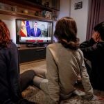 Una familia ve por televisión el mensaje del Rey por la crisis sanitaria al inicio de la pandemia