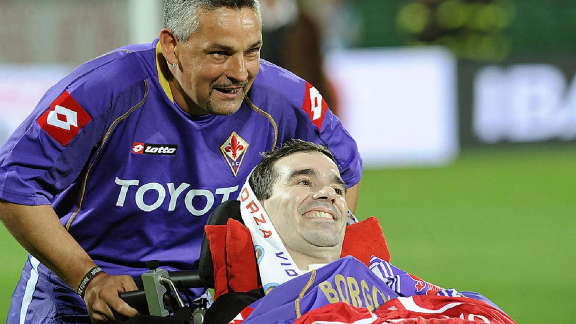 Roberto Baggio empuja la silla de ruedas de Stefano Borgonovo en un homenaje.