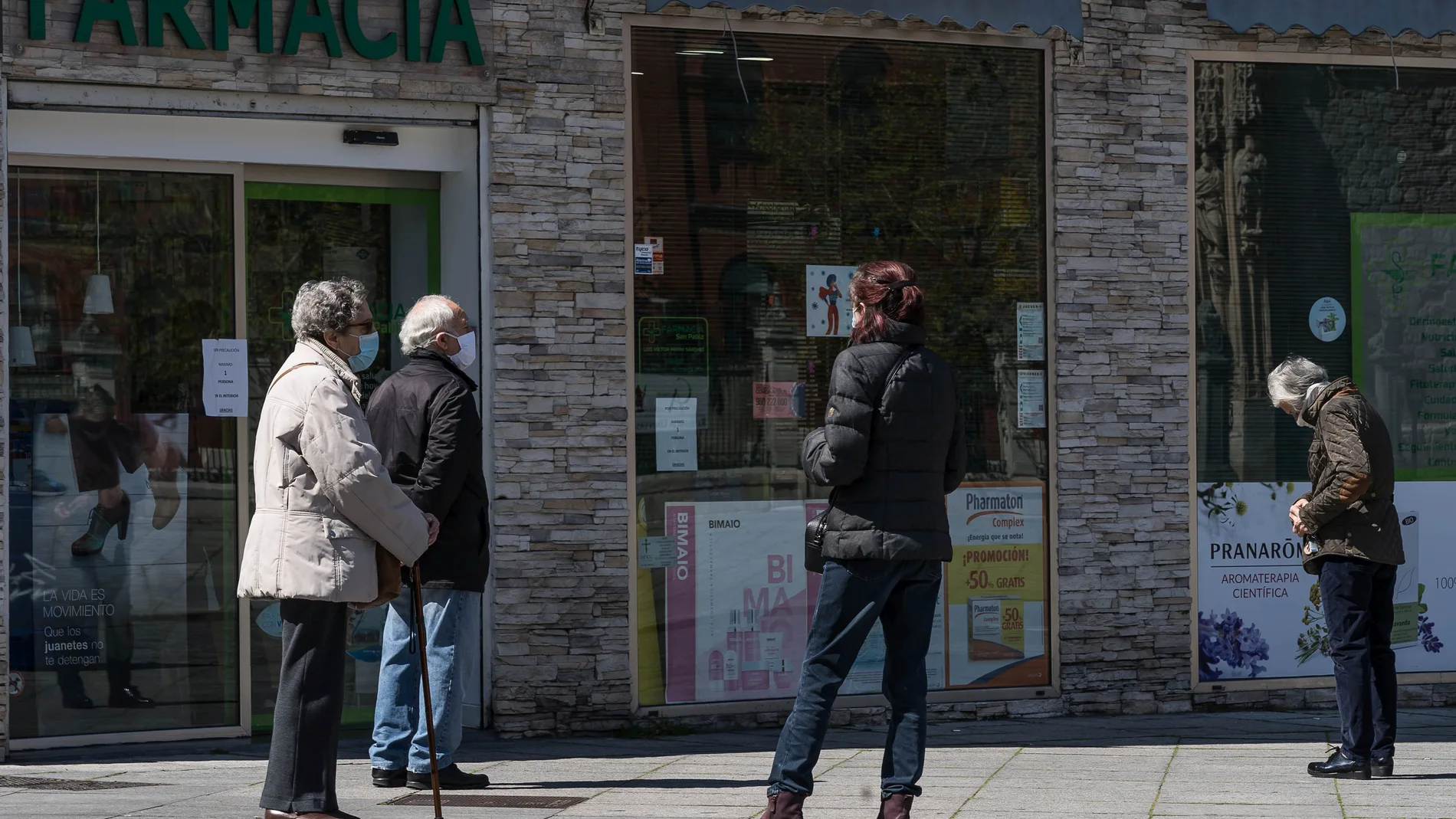 Personas esperan su turno para comprar en una farmacia de Valladolid durante el estado de alarma por el coronavirus.