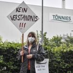 Una ciudadana alemana Magdalena Sawatzky protesta con un cartel que reza "no se entiende" frente al matadero cerrado por un brote de covid-19