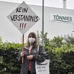 Una ciudadana alemana Magdalena Sawatzky protesta con un cartel que reza &quot;no se entiende&quot; frente al matadero cerrado por un brote de covid-19