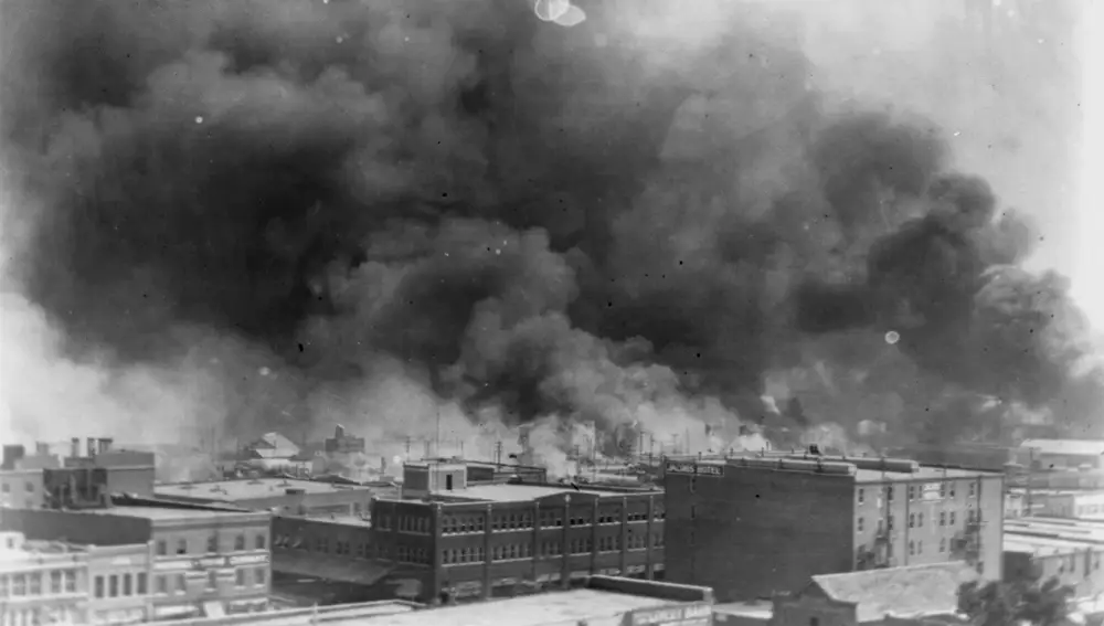 Imagen de Tulsa de 1921 con varios edificios ardiendo en el distrito conocido como Black Wall Street, donde decenas de negros fueron asesinados por blancos