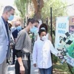 Los Reyes conversan con un niño, que les explican un mural, durante una visita a un centro de Aldeas Infantiles, en San Lorenzo de El Escorial