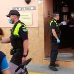 Un policía local entrega una carta certificada urgente al dueño de la pensión Zagora en Algeciras (Cádiz), que se encuentra aislada con una veintena de personas dentro por un brote de coronavirus