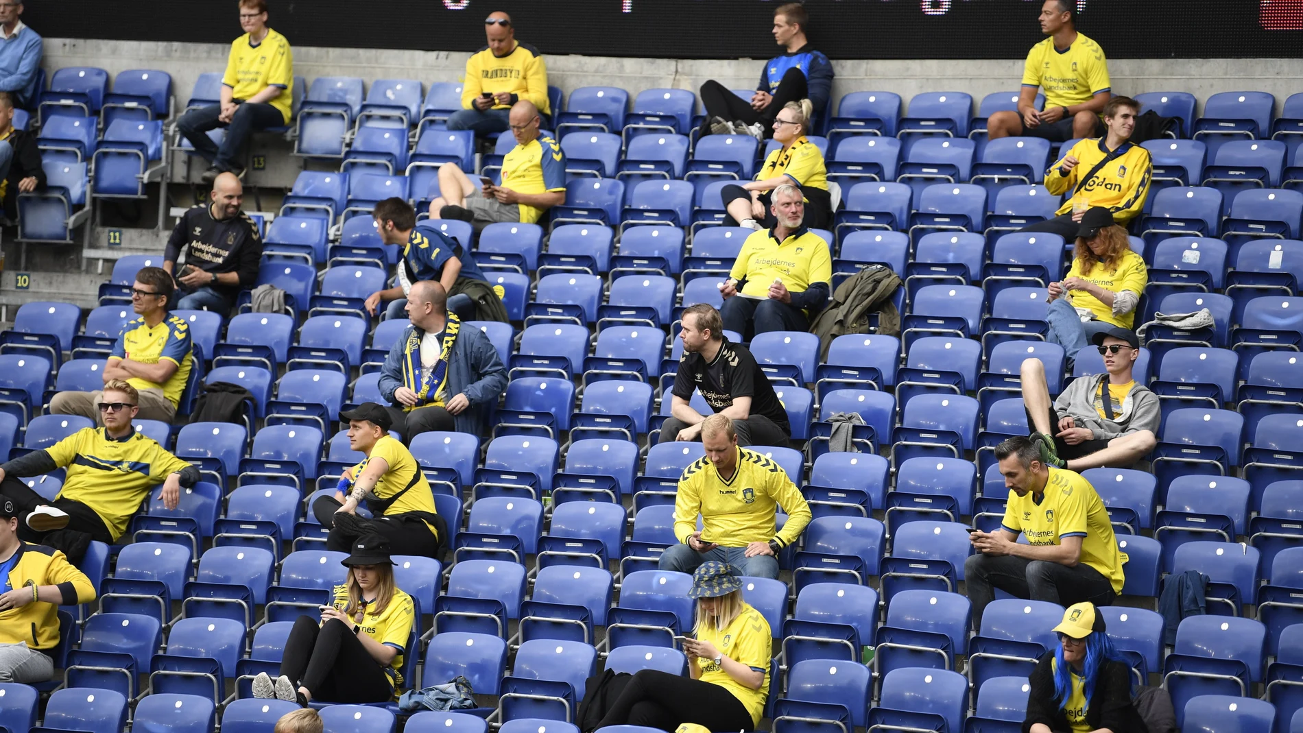 Los hinchas asisten manteniendo asientos libres a un partido de fút bol en el estadio de Broendby el pasado 21 de junio